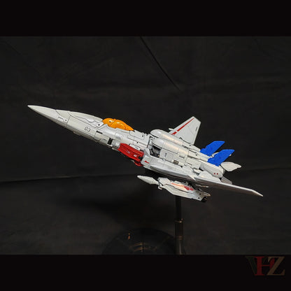 Side view of Collection Space CS-03 Starqueen Starscream jet mode figure, gray with red and blue accents, orange cockpit, "03" marking, on black stand.