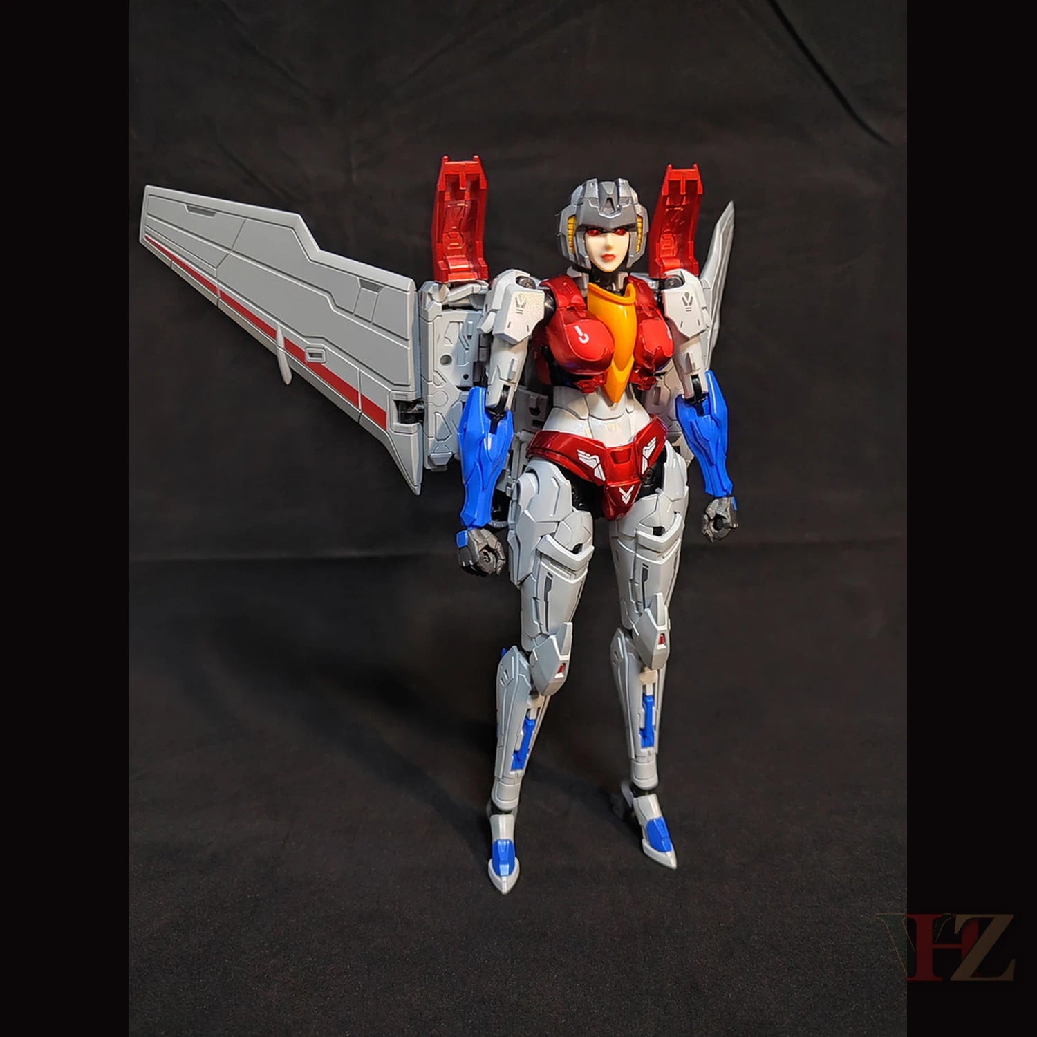 Collection Space CS-03 Starqueen Starscream Mecha Girl standing upright, white/red/blue body, large wing, against black background.
